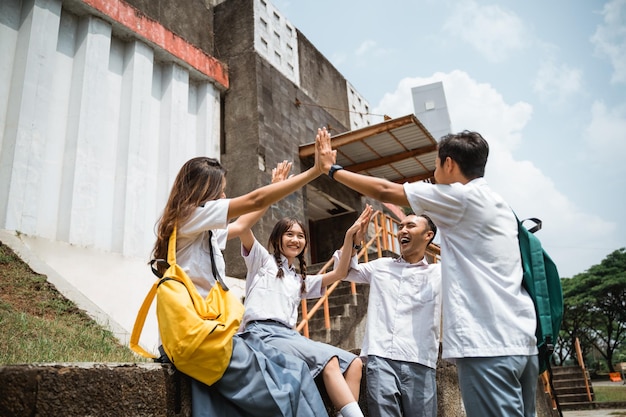 Foto estudiantes de secundaria asiáticos tomados de la mano mientras forman un sindicato