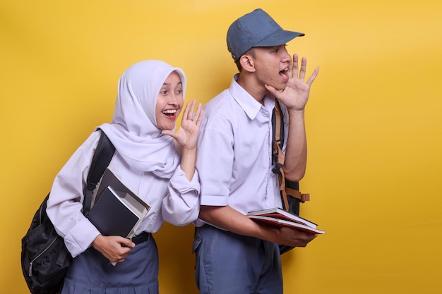 Estudiantes de secundaria indonesios en uniforme blanco y gris gritando hacia un lado