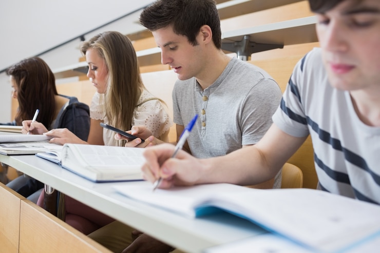 Foto estudiantes sentados en el escritorio en la sala de conferencias