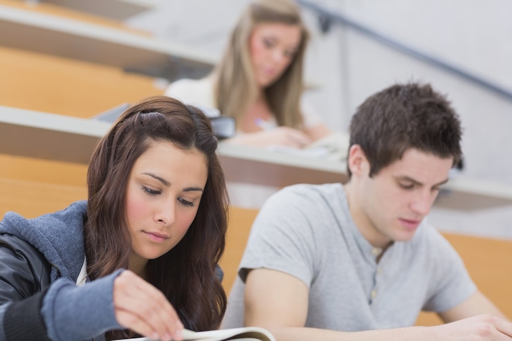 Foto estudiantes sentados en la sala de conferencias aprendiendo
