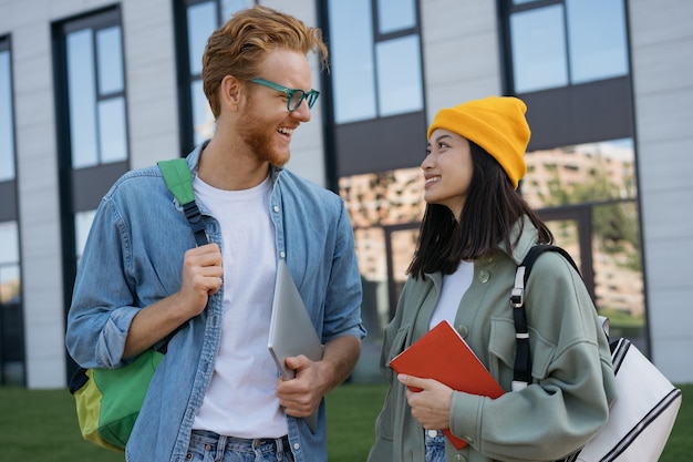 Estudiantes sonrientes hablando y caminando en el campus universitario