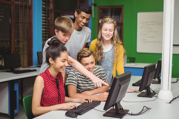 Estudiantes sonrientes que estudian en el aula de informática