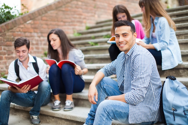 Estudiantes sonrientes sentados en una escalera