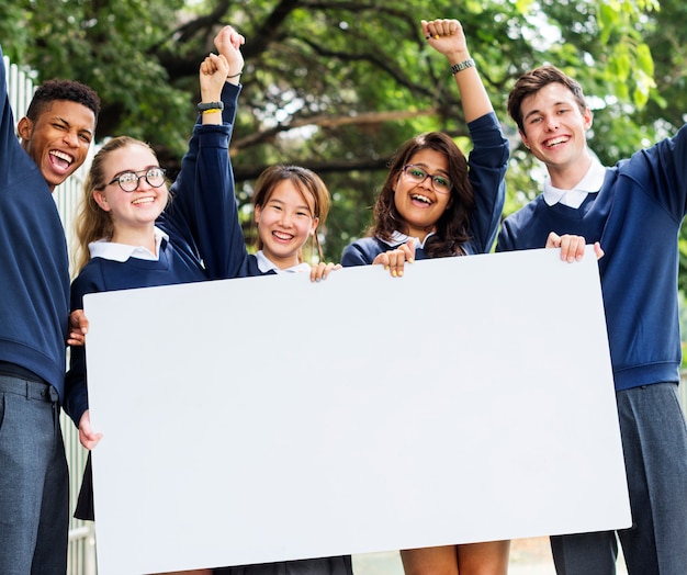 Foto estudiantes sosteniendo una pizarra