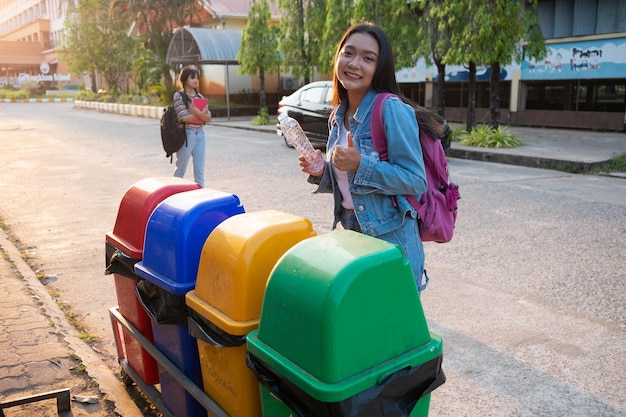 Los estudiantes tiran botellas de plástico a la basura en la escuela