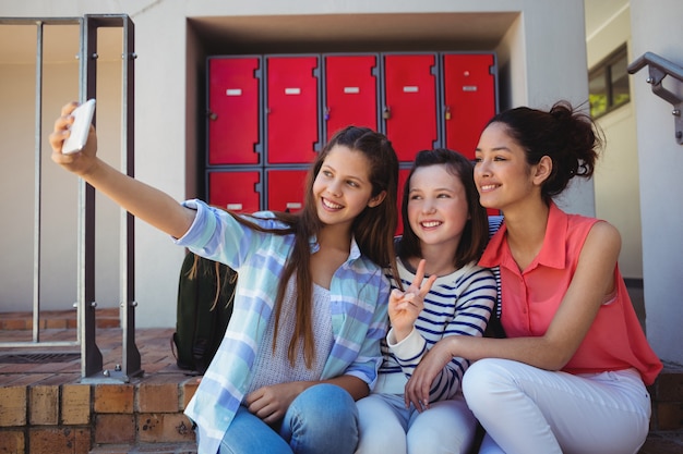 Estudiantes tomando un selfie en teléfono móvil