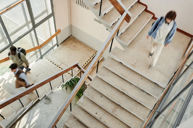 Estudiantes de la universidad moderna u otra escuela secundaria moviéndose a lo largo de las escaleras