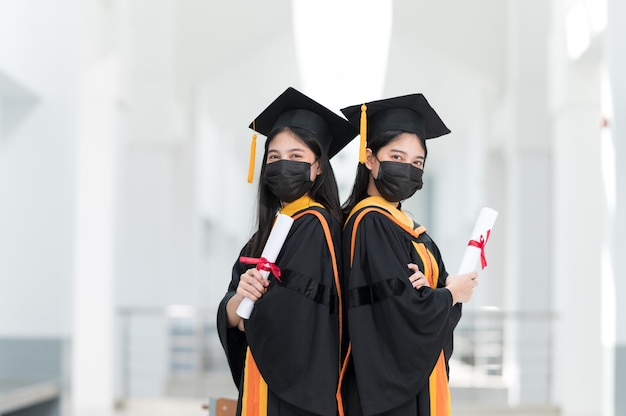 Las estudiantes universitarias, graduadas universitarias, visten sombreros negros, borlas amarillas y visten máscaras durante la epidemia.
