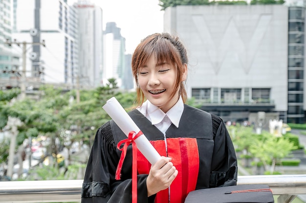 Estudiantes universitarios felices mujer asiática con diploma de graduación