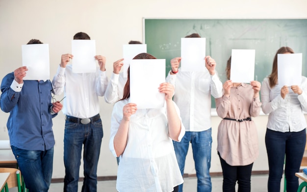 Estudiantes universitarios con papeles en blanco