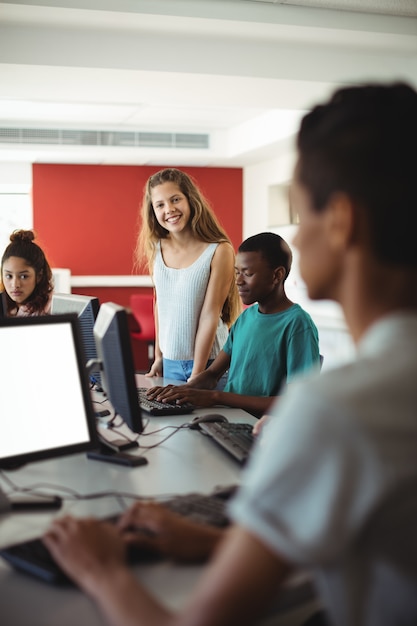 Foto estudiantes usando computadora en el aula