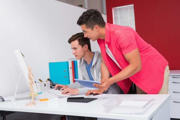 Estudiantes usando la computadora y tableta juntas