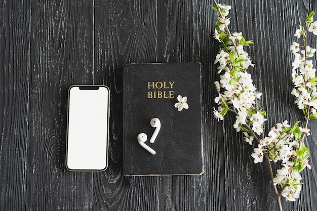 Estudiar la adoración de la Biblia concepto en línea Iglesia en línea Domingo nuevo concepto normal Biblia teléfono celular y auriculares sobre un fondo de madera Iglesia en casa