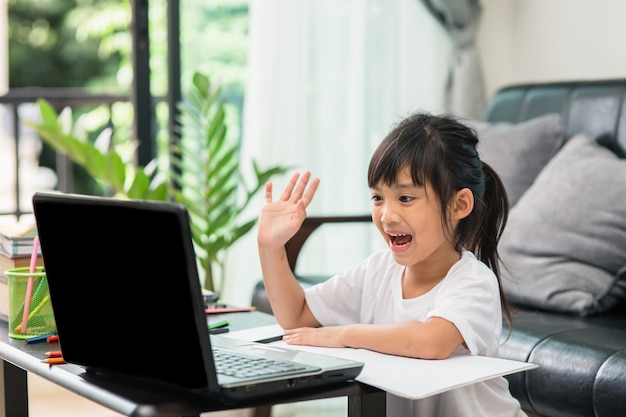 Estudio de clase de aprendizaje en línea de estudiantes asiáticos en línea con laptop en casa.