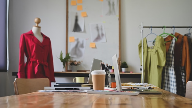 Estudio de diseñador de moda con mesa de trabajo.