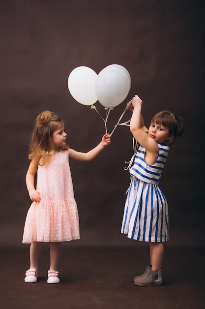 Estudio de dos niñas modelos con globos