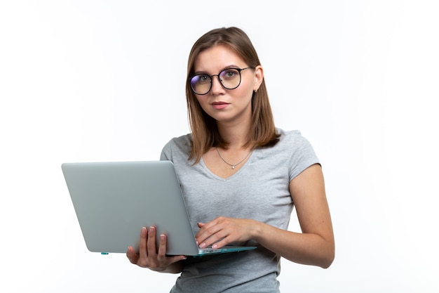 Estudio, educación, concepto de personas. mujer joven inteligente en vasos mensajes de texto algo en la computadora portátil.