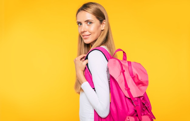 Estudio, educación, universidad, colegio, concepto de posgrado sobre fondo amarillo. Retrato de hermosa mujer rubia sonriente. Joven estudiante con mochila