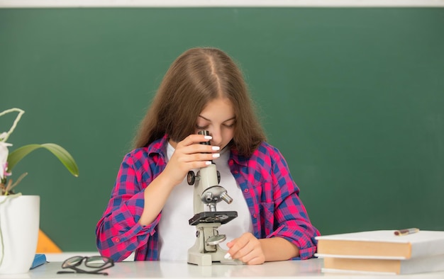 Estudio infantil con microscopio en ciencia de fondo de pizarra