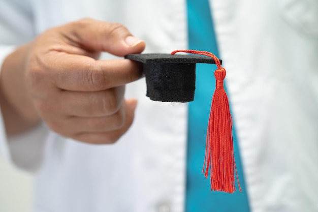 Estudio de médico asiático aprender con sombrero de brecha de graduación en sala de hospital concepto de medicina de educación de genio brillante inteligente