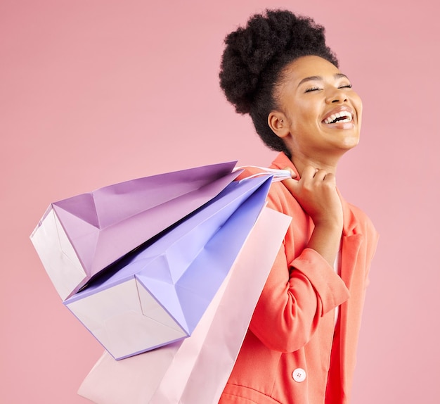 Estudio de mujer africana y bolsa de compras sonriente con venta de descuento y pensamiento de fondo rosa Promoción minorista de niña de la generación z joven y feliz por la experiencia del cliente y la moda para la idea de regalo