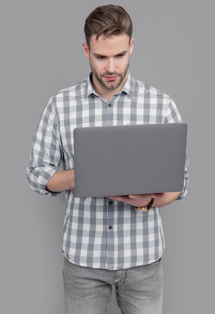 Estudio de programador informático Desarrollador de software usando computadora portátil Hombre serio escribiendo en computadora portátil Usuario aislado en gris