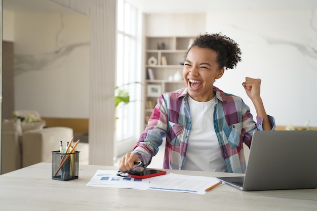 Estudio remoto en casa El examen se pasa con éxito Excelente adolescente celebrando su victoria