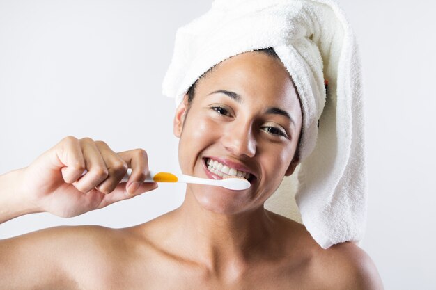 Estudio Retrato de joven y bella mujer posando con cepillo de dientes