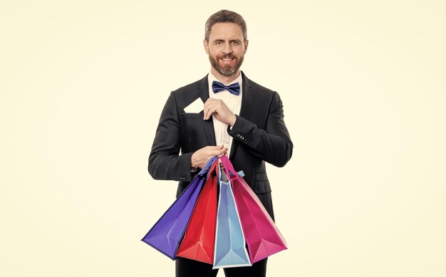 estudio tiro esmoquin hombre sostener bolsa de compras y tarjeta en el bolsillo compra de esmoquin hombre ir de compras esmoquin hombre con bolsa de compras aislado en fondo blanco esmoquin hombre después de las compras