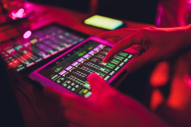 Foto estúdio trabalhando com consoles de mistura de som e luz mãos de engenheiro de som trabalhando na gravação estúdio misturador ajustando o volume de um mixador de som console de misturador de áudio com tablets de mixador digital