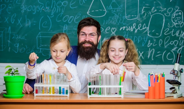 Estudios de investigación Profesor de ciencias y alumnos haciendo trabajo de investigación Profesor y niños de escuela primaria sosteniendo tubos de ensayo en laboratorio de investigación La investigación experimental está realizando una prueba de laboratorio