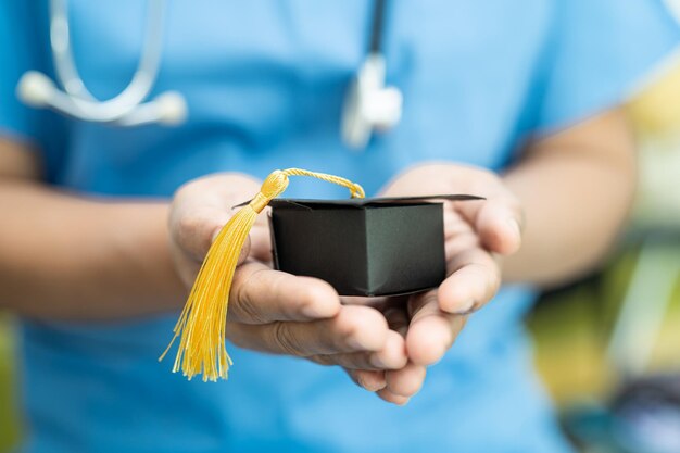 Estudios de médicos asiáticos aprender con graduación brecha sombrero en la sala del hospital inteligente brillante genio educación concepto de medicina