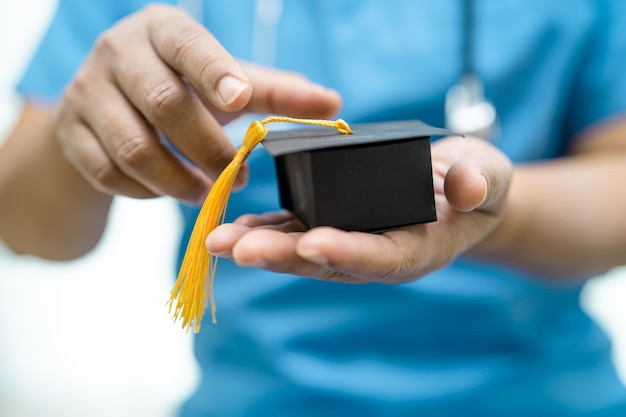 Estudios de médicos asiáticos aprender con graduación brecha sombrero en la sala del hospital inteligente brillante genio educación concepto de medicina