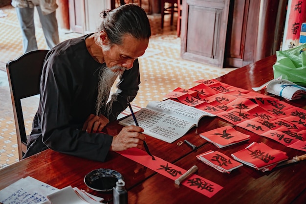 Estudioso vietnamita escreve caligrafia no festival de caligrafia Long Son é uma tradição popular durante o feriado de Tet Escrevendo dísticos para o Festival da Primavera do ano novo