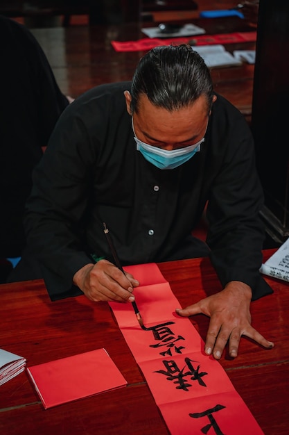 Estudioso vietnamita escreve caligrafia no festival de caligrafia Long Son é uma tradição popular durante o feriado de Tet Escrevendo dísticos para o Festival da Primavera do ano novo