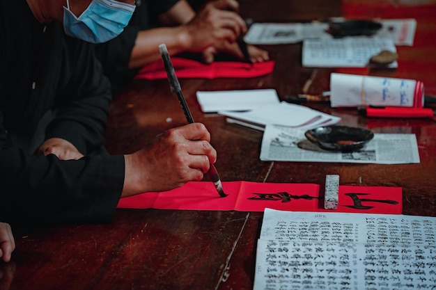 Estudioso vietnamita escreve caligrafia no festival de caligrafia Long Son é uma tradição popular durante o feriado de Tet Escrevendo dísticos para o Festival da Primavera do ano novo