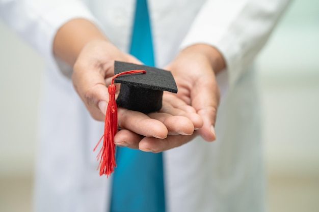 Estudo de médico asiático aprende com chapéu de graduação na enfermaria do hospital conceito de medicina de educação de gênio brilhante inteligente