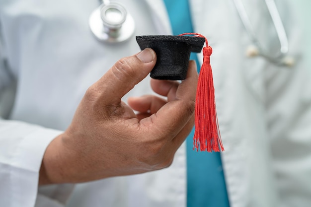 Estudo de médico asiático aprende com chapéu de graduação na enfermaria do hospital conceito de medicina de educação de gênio brilhante inteligente