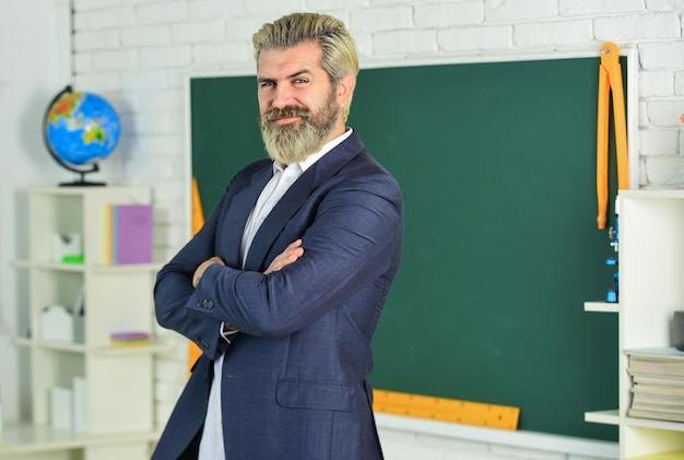 Estudo e educação Escola moderna Dia do conhecimento De volta à escola Homem barbudo emocional no quadro-negro da sala de aula Ensinar com interesse Verificar os resultados de aprendizagem alcançados Lição da escola do professor