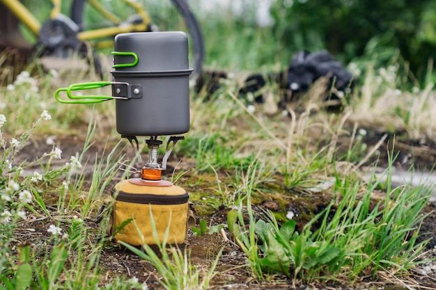 Estufa de gas turística para acampar y recreación en el fondo de una bicicleta en la naturaleza