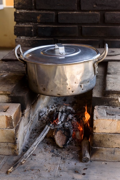 Estufa de leña con cacerola de aluminio.