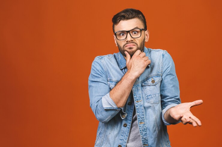 Foto estupefacto atractivo joven barbudo mira con asombro a la cámara
