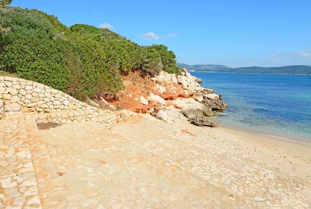 Etapas rochosas na praia de Cala Dragunara na Sardenha