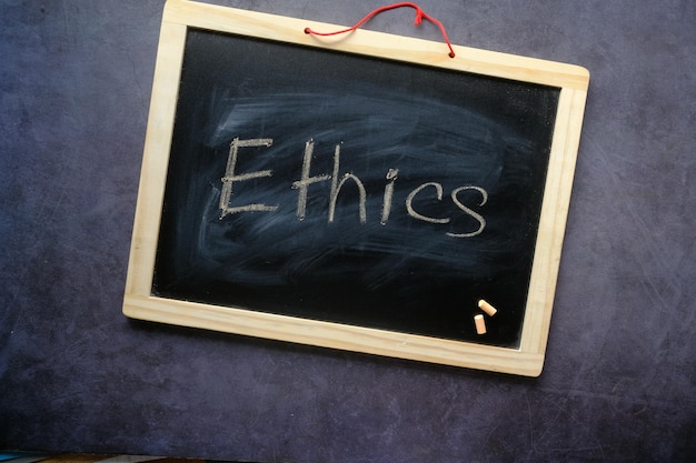 Foto ethik-wort auf einer kreidetafel auf schwarzem hintergrund