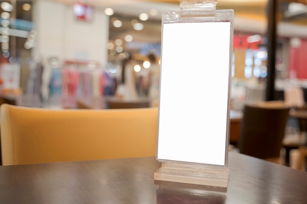 Etiqueta en blanco blanco en la mesa. Soporte para tarjeta de tienda de acrílico