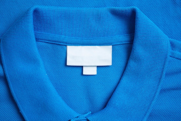 Foto etiqueta en blanco de ropa de lavandería en fondo de textura de tela de camisa azul