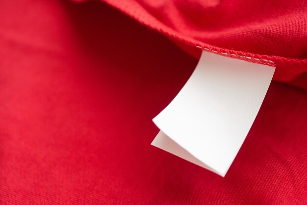 Etiqueta branca de instruções de lavagem de roupas para lavar roupas em camisa de algodão vermelha