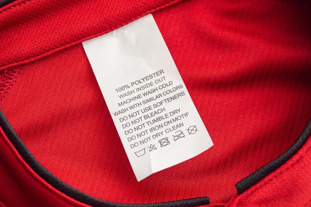 Etiqueta branca de instruções de lavagem de roupas para lavar roupas em camisa esporte de poliéster de jersey vermelho