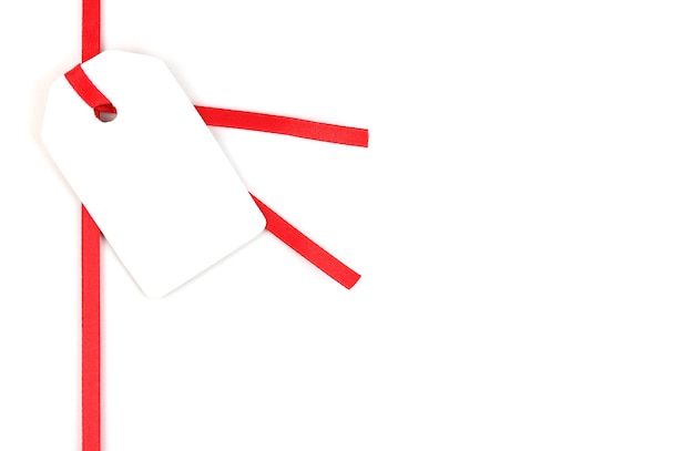 Etiqueta de presente em branco em fita de cetim vermelha isolada no branco