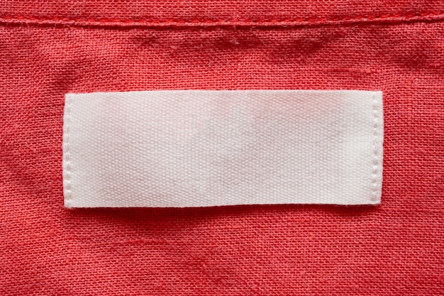 Foto etiqueta de roupa em branco no fundo de textura de tecido de camisa de linho